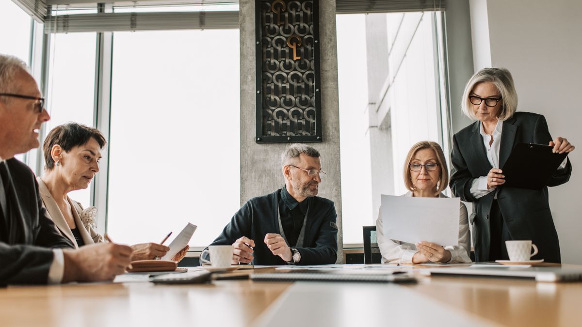 Business leaders reviewing documents together around a meeting table